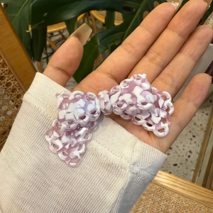 Primo piano di un fermaglio per capelli a fiocco in acetato viola e bianco traforato