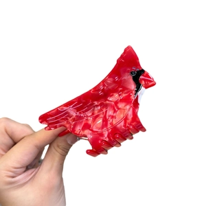 Red cardinal bird hair claw clip made of acetate with marble texture on white background