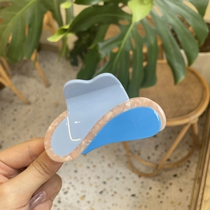 Creative sky blue cowboy hat hair claw clip with pink marble finish on tropical background