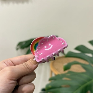 Pink cloud-shaped acrylic hair claw clip with rainbow pattern and small rhinestones
