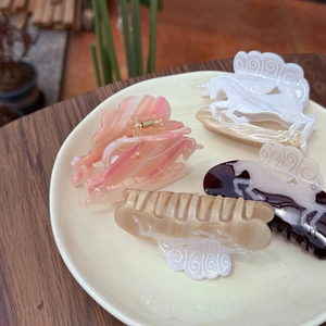 Set of four unicorn shaped acetate hair claws in pastel pink and cream colors