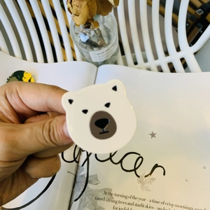 Detailed close-up of a cute white polar bear acetate hair clip held in hand for scale