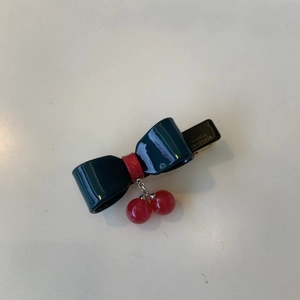 Handmade acetate bow hair clip with cherry pendant and gold label in dark green