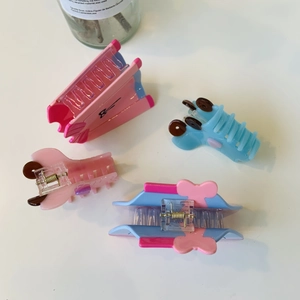 Flat lay of diverse acetate hair claws in pastel pink and blue with bow and bone shapes