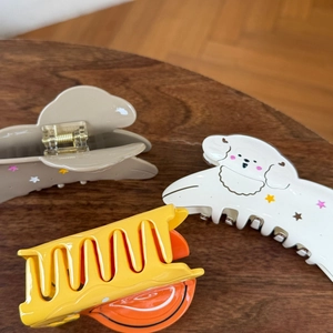 Detailansicht bunter Haarklammern mit Sternen und Cartoon-Motiven auf Holztisch