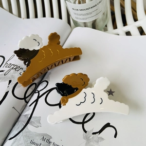 Close-up of cute cartoon dog acetate hair claws in brown and white on a magazine