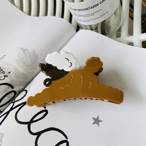 Detailed view of the brown and white puppy hair claw clip on a stylish lifestyle background