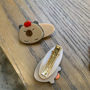 Detailed view of Capybara hair clip with apple decor and metal duckbill fastener