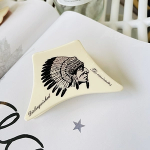 Close-up of a cream-colored acrylic hair claw featuring an Indian chief portrait design