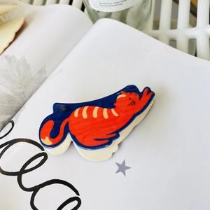 Artistic cat shaped acrylic hair claw clip with orange stripes on blue background