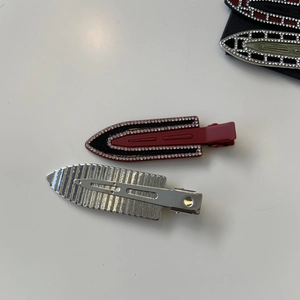 Detail view of burgundy rhinestone duckbill hair clip with silver textured metal back