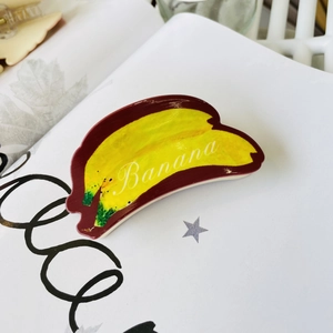 Macro shot of creative yellow banana acrylic hair claw clip with Banana text detail