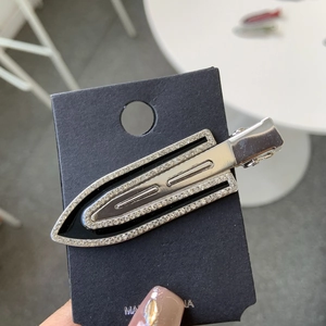 Silver geometric arrow hair clip with sparkling rhinestones on black card packaging