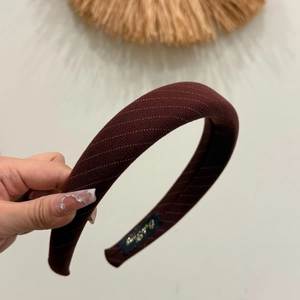 Minimalist burgundy thick sponge headband with white dotted stripe texture and label