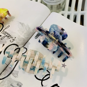 Close-up of marble pattern acetate hair claws on a magazine for a stylish look
