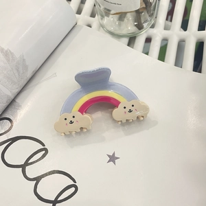 Cute rainbow-shaped hair claw clip with cream clouds and smiling faces in pink blue yellow