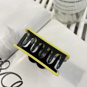 Detailed view of bicolor pumpkin hair claw clip in yellow and black resin finish