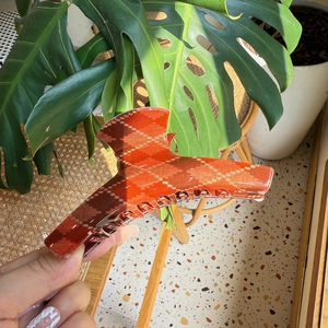 Close-up of red plaid claw clip with geometric pattern and sturdy metal spring detail