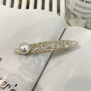 Elegant cream resin hair clip with shiny shell flakes and a large pearl ornament