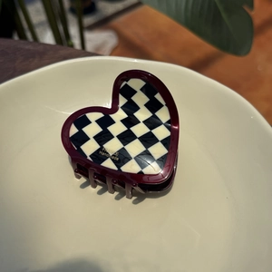 Deep red heart-shaped acetate hair claw with classic black and white checkered pattern