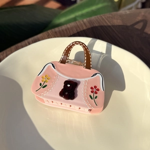 Pink bear handbag shaped hair claw with flower patterns and white stitching details