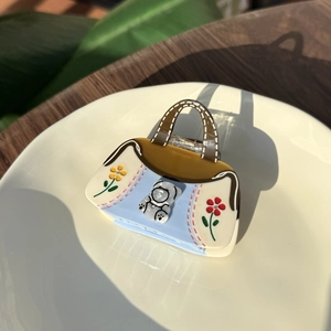 Cute acetate handbag claw clip with flower pattern and 3D bear on a ceramic plate