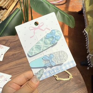 Blue ballet style hair clips with bows and stars on display card for women