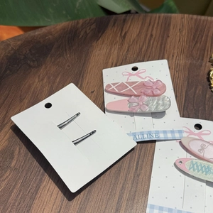 Detailed view of pink and silver bow star hair clips with metal duckbill backings