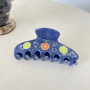 Grande pince à cheveux avec texture denim, motifs citron et strass brillants en gros plan