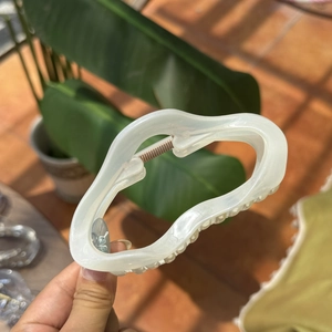 Minimalist cloud-shaped hair claw clip with white pearlescent finish and red dot pattern