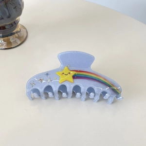 Détail de la grande pince à cheveux bleu clair pailleté avec arc-en-ciel et étoiles