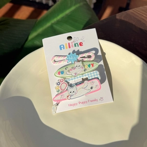 Dettaglio del set di 4 fermagli per capelli in acrilico con gatti e glitter su carta