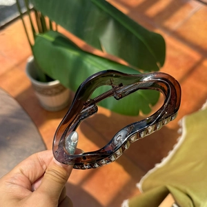 Detail view of large dark brown wavy hair claw clip with transparent resin finish