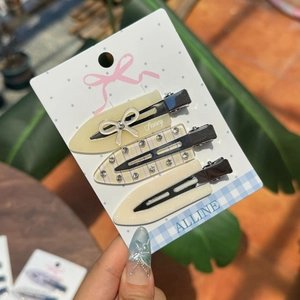 Dreiteiliges Haarspangen-Set aus Acryl mit Schleife und Strasssteinen auf Display-Karte