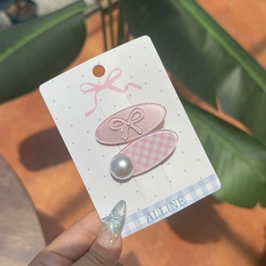 Détail de pinces à cheveux à nœud rose et perles sur carte de présentation