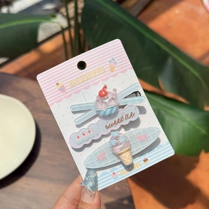 Detailed close-up of cute ice cream and dessert themed hair clips on a pink card