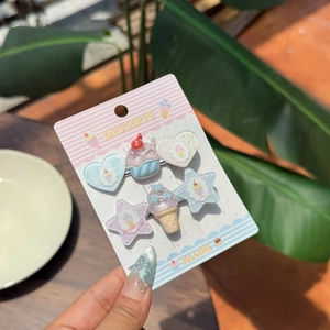 Detailed view of 5-piece resin hair clips with dessert shapes on a pink branded card