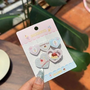 Detail view of five heart-shaped acrylic hair clips with sweet dessert illustrations