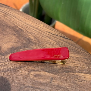 Dettaglio del fermaglio per capelli rosso in acetato con scritta dorata France Handmade