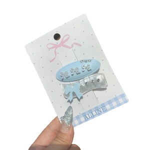 Set of two sweet blue bow hair clips with rhinestones on a decorative white card