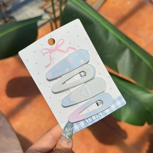 Set of 4 pastel sea salt style hair clips with stars and hearts on a display card