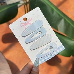 Detail of light blue checkered and polka dot BB hair clips set on display card