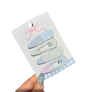 Set of four pastel BB hair clips with heart and star prints on blue plaid card