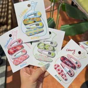Detail of four-piece fruit hair clips set featuring lemon and strawberry designs