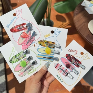Detailed set of acrylic fruit hair clips with strawberry and lemon patterns on card