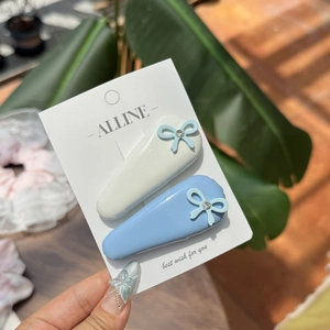 Lot de deux pinces à cheveux en cuir blanc et bleu avec détails en strass brillants