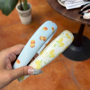 Detail of high-top padded headbands with lemon and orange prints in fresh cotton fabric