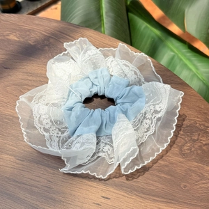 Gros plan d'un chouchou bleu clair avec dentelle blanche multicouche et mesh fin