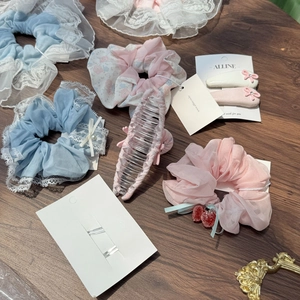 Collection détaillée de chouchous en dentelle et pinces à cheveux sur fond de bois foncé