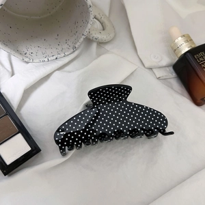 Vintage black and white polka dot hair claw clip for high ponytail on white shirt